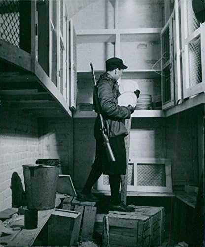 Vintage fotografija muškarca koji traži unutar kuhinje.
